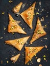 Homemade Greek feta cheese Phyllo Triangles pies with honey and pistachios. Cooking sweets turkish, or arabic traditional ramadan