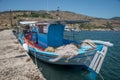 Greek fishing boat tied up at a cement pier