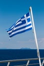 Greek flag on the blue sky and blue sea background at the aft of a ferry boat. Vertical Royalty Free Stock Photo
