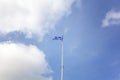 Greek flag on flagpole fluttering in the wind against blue sky w Royalty Free Stock Photo