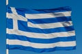 Greek flag on pole waving over blue background Royalty Free Stock Photo