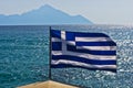 Greek flag on a sailing ship with holy mountain Athos in background Royalty Free Stock Photo