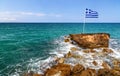 Greek flag, sea and shore in the background. Crete, Greece Royalty Free Stock Photo