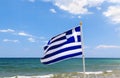 Greek flag, sea and shore in background. Crete, Greece Royalty Free Stock Photo