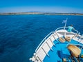 Greek flag waving on the bow of a boat sailing toward the island of Chrissi or the Caribbean in Greece