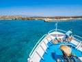 Greek flag waving on the bow of a boat sailing toward the island of Chrissi or the Caribbean in Greece