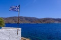 Greek flag waving over blue sky and sea in Greece Royalty Free Stock Photo
