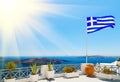 Greek flag waving at sun in Oia, Santorini, Greece Royalty Free Stock Photo