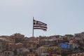 Greek flag waving at sunset. Houses on the background Royalty Free Stock Photo