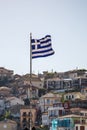 Greek flag waving at sunset. Houses on the background Royalty Free Stock Photo