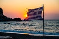 Greek flag waving at sunset on a sandy beach in Crete, Greece Royalty Free Stock Photo