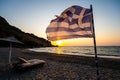 Greek flag waving at sunset on a sandy beach in Crete, Greece Royalty Free Stock Photo