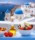 Greek food against famous churches in Oia village on Santorini island in Greece Royalty Free Stock Photo