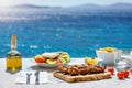 Greek food concept with farmers salad and souvlaki skewers in front of the Aegean sea