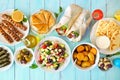 Greek food table scene, overhead view on a blue wood background Royalty Free Stock Photo