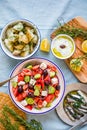 Greek food table scene, top view . Variety of items including greece salad, cucumber dip Tzatziki, Anchovy fillets, lemon potatoes Royalty Free Stock Photo