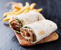 Greek gyro wrap cut in half and served with fries