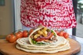 Greek Gyros street food for take away, nicely wrapped with tomato, souvlaki, Greek salad, onion and French fries Royalty Free Stock Photo