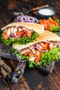Greek gyros wrapped in pita breads with vegetables and sauce. Dark wooden background. Top view Royalty Free Stock Photo