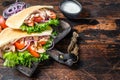Greek gyros wrapped in pita breads with vegetables and sauce. Dark wooden background. Top view. Copy space Royalty Free Stock Photo