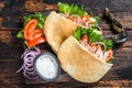 Greek gyros wrapped in pita breads with vegetables and sauce. Dark wooden background. Top view Royalty Free Stock Photo