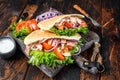 Greek gyros wrapped in pita breads with vegetables and sauce. Dark wooden background. Top view Royalty Free Stock Photo