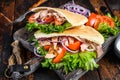 Greek gyros wrapped in pita breads with vegetables and sauce. Dark wooden background. Top view Royalty Free Stock Photo