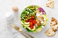 Greek inspired salad with grilled chicken meat, vegetables and feta cheese in a bowl on a table, with olive oil dressing Royalty Free Stock Photo