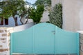 Greek Island, Cyclades. Light blue yard entrance, view of blooming plant and fruit tree