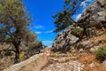 Greek landscape. Paved stairs, hills, mountains, bushes. Olive, mastic trees. Clear blue sky, beautiful clouds, sea Royalty Free Stock Photo