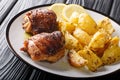Greek lemon potatoes with garlic and herbs served with chicken thigh grilled close-up. horizontal Royalty Free Stock Photo