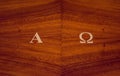 Greek letters alpha and omega carved on a wooden pulpit in a church