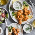 Greek lunch - chicken kebabs, greek salad, tzatziki, flatbreads and white wine. On a light background Royalty Free Stock Photo