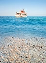 Greek marble beach, blue sea and cruise boat