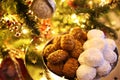 Greek melomakarona and kourabies in front of the Christmas tree - traditional Christmas cookies with honey and nuts and sugar buns