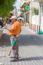 Greek men, cleaning city street during his break with cellphone Royalty Free Stock Photo