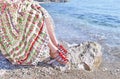 Greek model advertises bohemian sandals and clothes at the beach