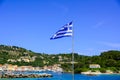 The Greek National Flag over seascape, beautiful turquoise sea , summer travel vacation. Royalty Free Stock Photo