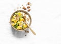 Greek natural yogurt with tropical fruits and granola on a light background, top view. Natural yogurt with kiwi, mango and