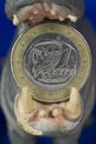 Greek one euro coin in mouth of hippo figurine Royalty Free Stock Photo