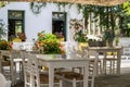 Greek outdoors tavern with table and chair at Kithira island Milopotamos village. Pots with flowers