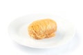 Greek pastry Kataifi with shredded filo dough stuffed with almond nuts, in honey syrup, isolated on white plate