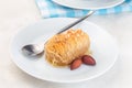 Greek pastry Kataifi with shredded filo dough stuffed with almond nuts, in honey syrup, on white plate, horizontal