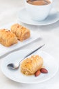 Greek pastry Kataifi with shredded filo dough stuffed with almond nuts, in honey syrup, on white plate, served with cup of coffee Royalty Free Stock Photo