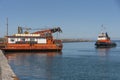 A Greek registered tugboat sailing towards a crane barge in Heraklion port, Crete.