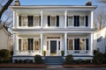 greek revival house with porch and large symmetrical windows