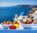 Greek salad against famous church in Oia village, Santorini island in Greece