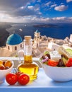 Greek salad against famous church in Oia village, Santorini island in Greece Royalty Free Stock Photo