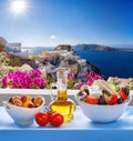 Greek salad against famous church in Oia village, Santorini island in Greece Royalty Free Stock Photo