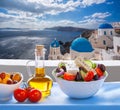 Greek salad against famous church in Oia village, Santorini island in Greece Royalty Free Stock Photo